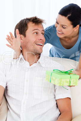 Amazed man receiving a present from his girlfriend