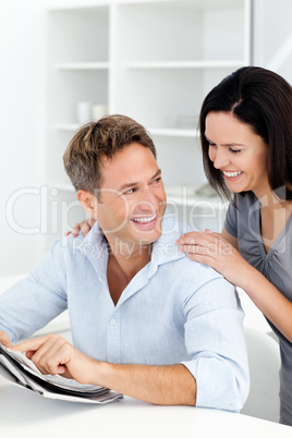 Happy man showing something on the newspaper to his girlfriend