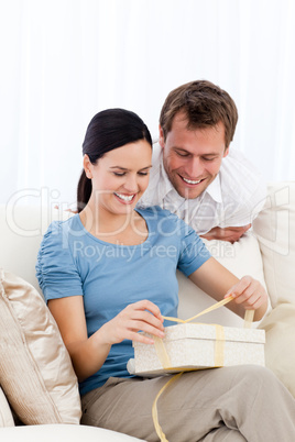 Lovely woman opening a present from her boyfriend