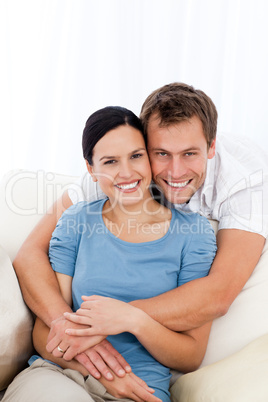 Portrait of a happy man hugging his girlfriend while relaxing on