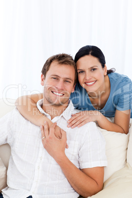 Passionate woman hugging her boyfriend while relaxing on the sof