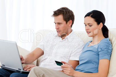 Pretty woman reading code on a credit card for his boyfriend