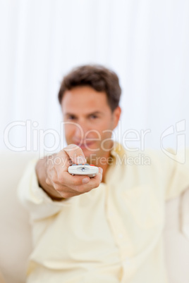 Close up of a man holding a remote on the sofa