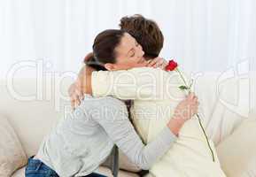 Lovely woman hugging his boyfriend after receiving a flower