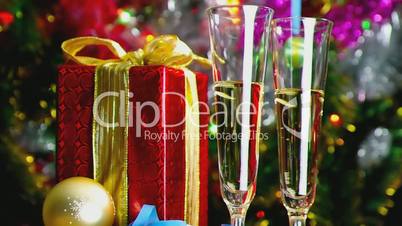 Two wine glasses and gift over blurred flickering background