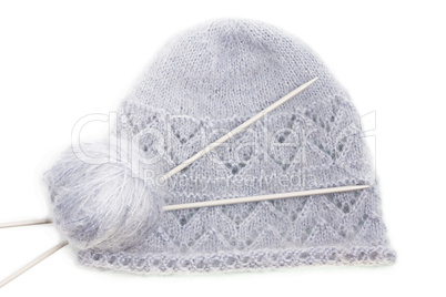Grey woolen knitted mohair cap with clew and knitting needles