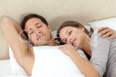 Serene woman lying on her boyrfriend's arms while sleeping