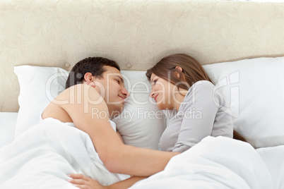 Tranquil couple looking at each other on their bed