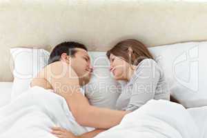 Tranquil couple looking at each other on their bed