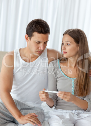 Man looking at a pregnancy test with his girlfriend
