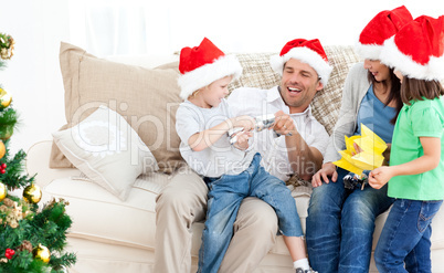 Father and son playing with a cracker on the sofa