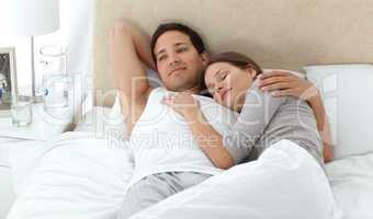 Man dreaming on his bed while relaxing with his girlfriend