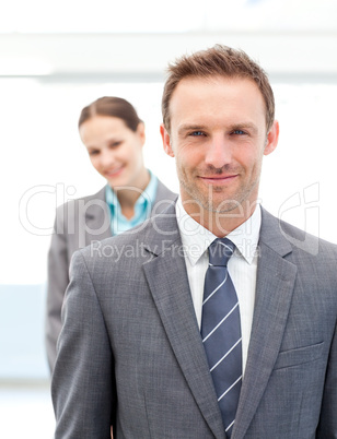 Two smiling business people posing in a row