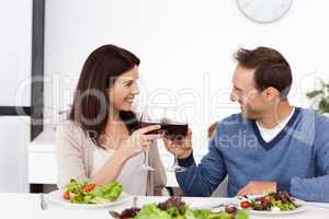 Lovely couple clinking glasses of red wine during lunch
