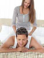 Pretty woman massaging her boyfriend sitting on his back