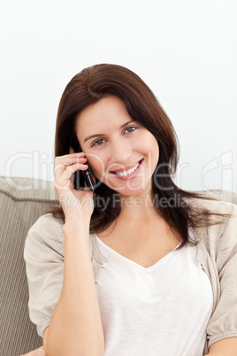 Lovely woman on the phone sitting on the sofa