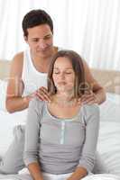 Relaxed woman being massaged by her boyfriend on their bed