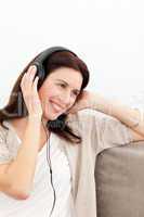 Woman smiling while listening music on the sofa
