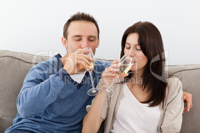 Relaxed couple drinking champagne on the sofa