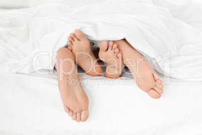 Close up of couple's feet while having fun in their bed