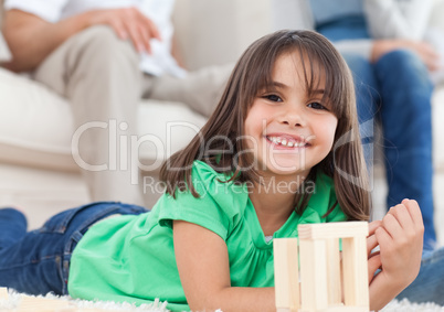 Cute little girl playing with dominoes in the living room