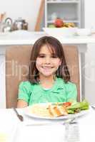 Cute little girl eating pasta and salad