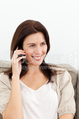 Cute woman on the phone sitting on the sofa