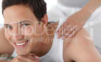 Portrait of a happy man receiving a massage from his girlfriend
