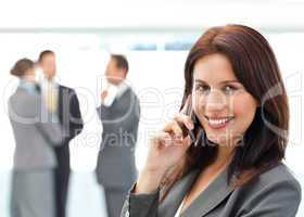 Cute businesswoman on the phone while her team discussing
