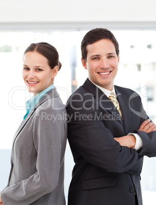 Happy businessman and businesswoman posing back to back