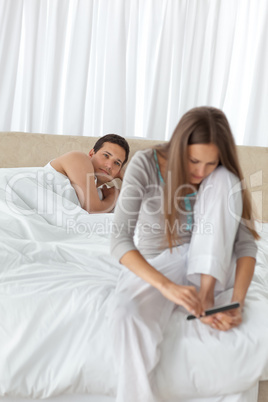 Patient man looking at his girlfriend filing her toenails on the