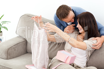 Passionate man giving a top to his girlfriend while relaxing on