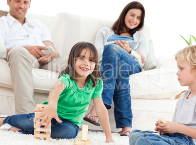 Happy children playing with dominoes in the living room