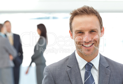 Happy businessman posing in front of his team