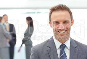 Happy businessman posing in front of his team