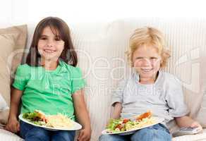 Happy brother and sister having TV dinner