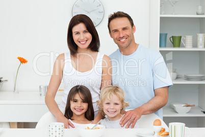 Adorable children posing with their parents in the kitchen