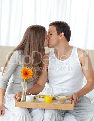 Happy woman kissing her boyfriend for bringing the breakfast