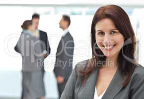 Happy businesswoman posing while her team discussing
