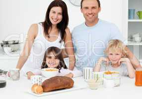 Cheerful family having breakfast together in the kitchen