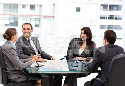 Handsome manager laughing during a meeting with his team