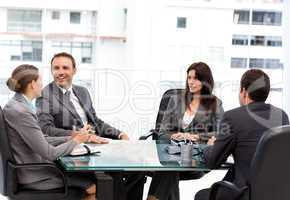 Handsome manager laughing during a meeting with his team