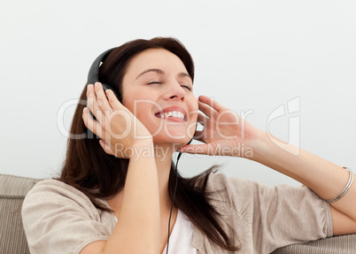 Happy woman enjoying a song on the sofa