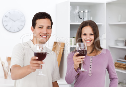 Young couple toasting with glasses of red wine