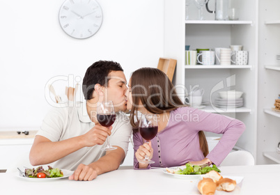 Lovely couple giving a toast while eating a salad
