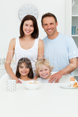 Happy parents posing with their children in the kitchen