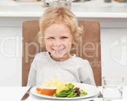 Cute little boy eating pasta and salad