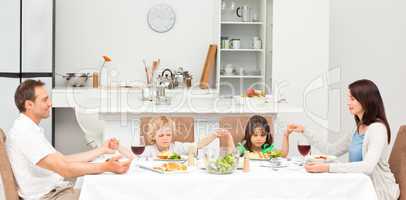 Concentrated family praying before having lunch