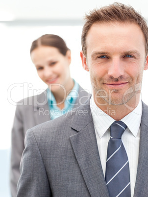 Confident businesswoman and businessman posing together in line