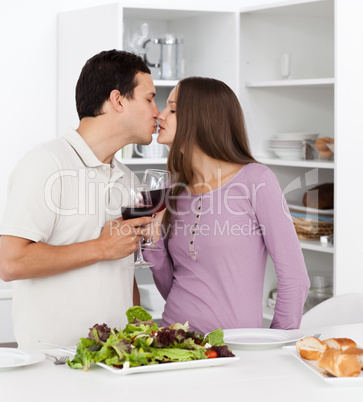 Cute couple kissing while having lunch in the kitchen